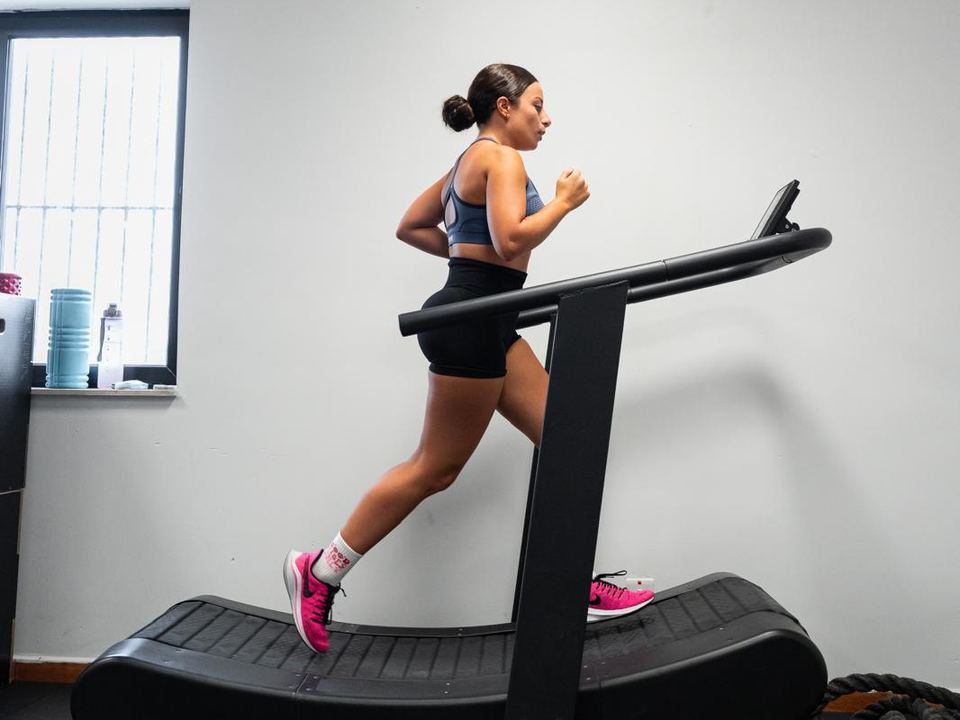 Member running on the curved treadmill at FitLab